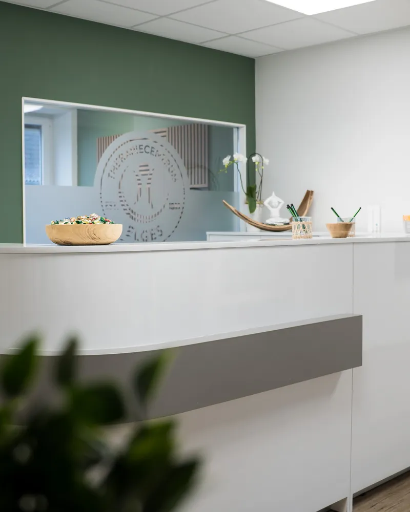 Empfangstheke des TherapieCentrum Elges in Herne mit Logo auf Glaswand und Holzdetails