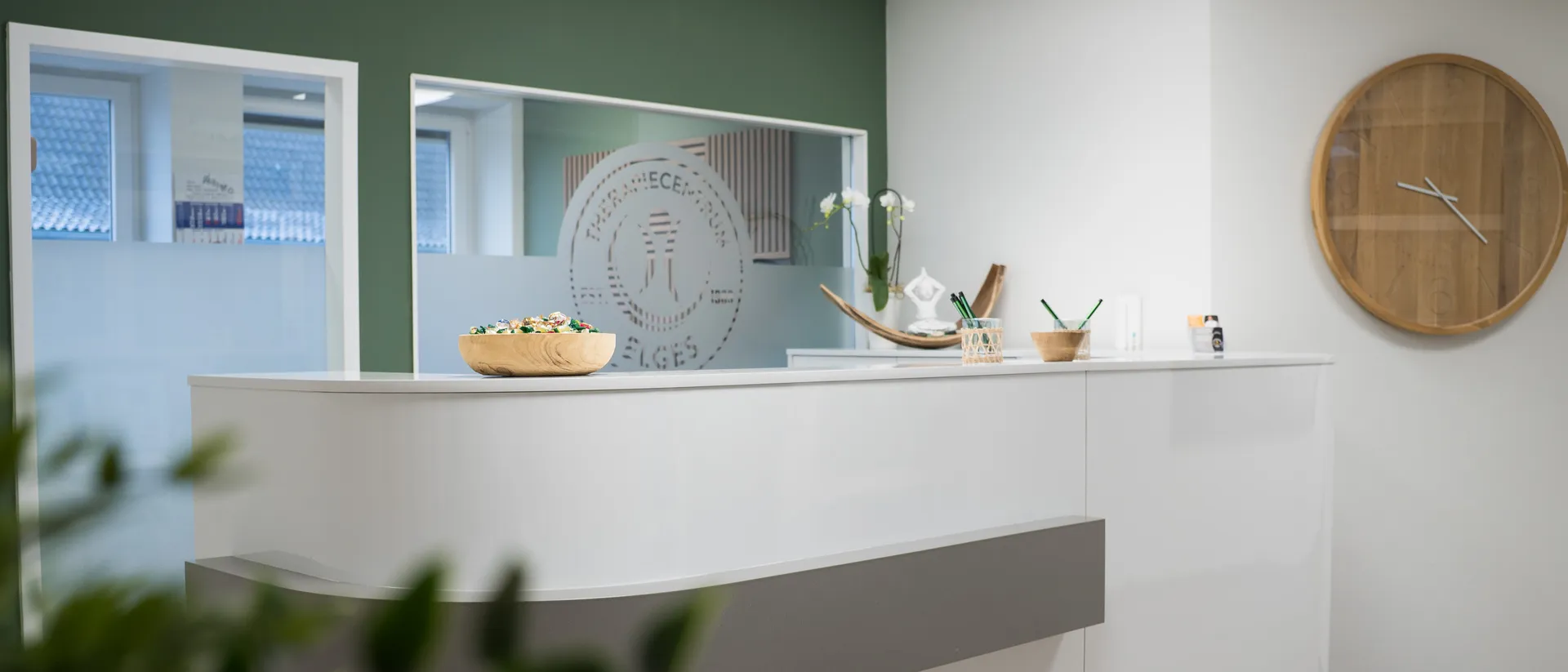 Empfangsbereich des TherapieCentrum Elges mit Logo-Glaswand