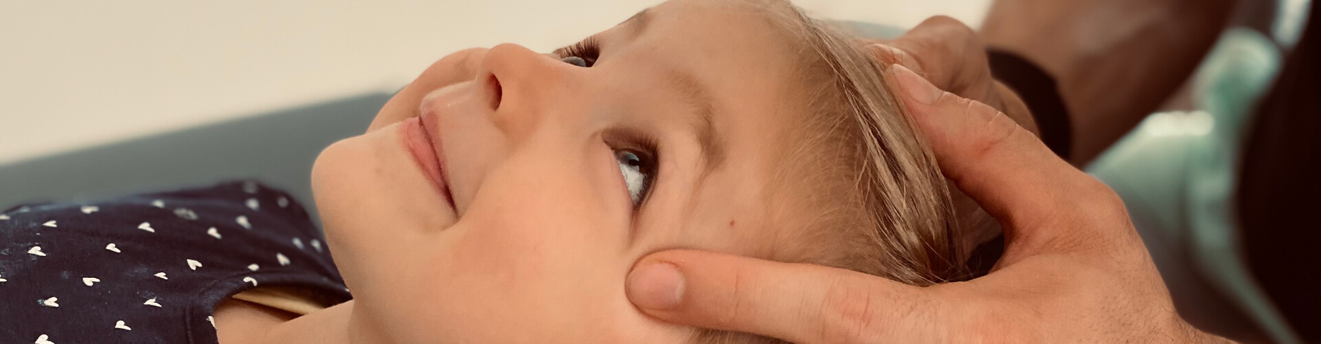 Kinderosteopathie Herne: Kinderosteopath behandelt den Kopf eines Kindes